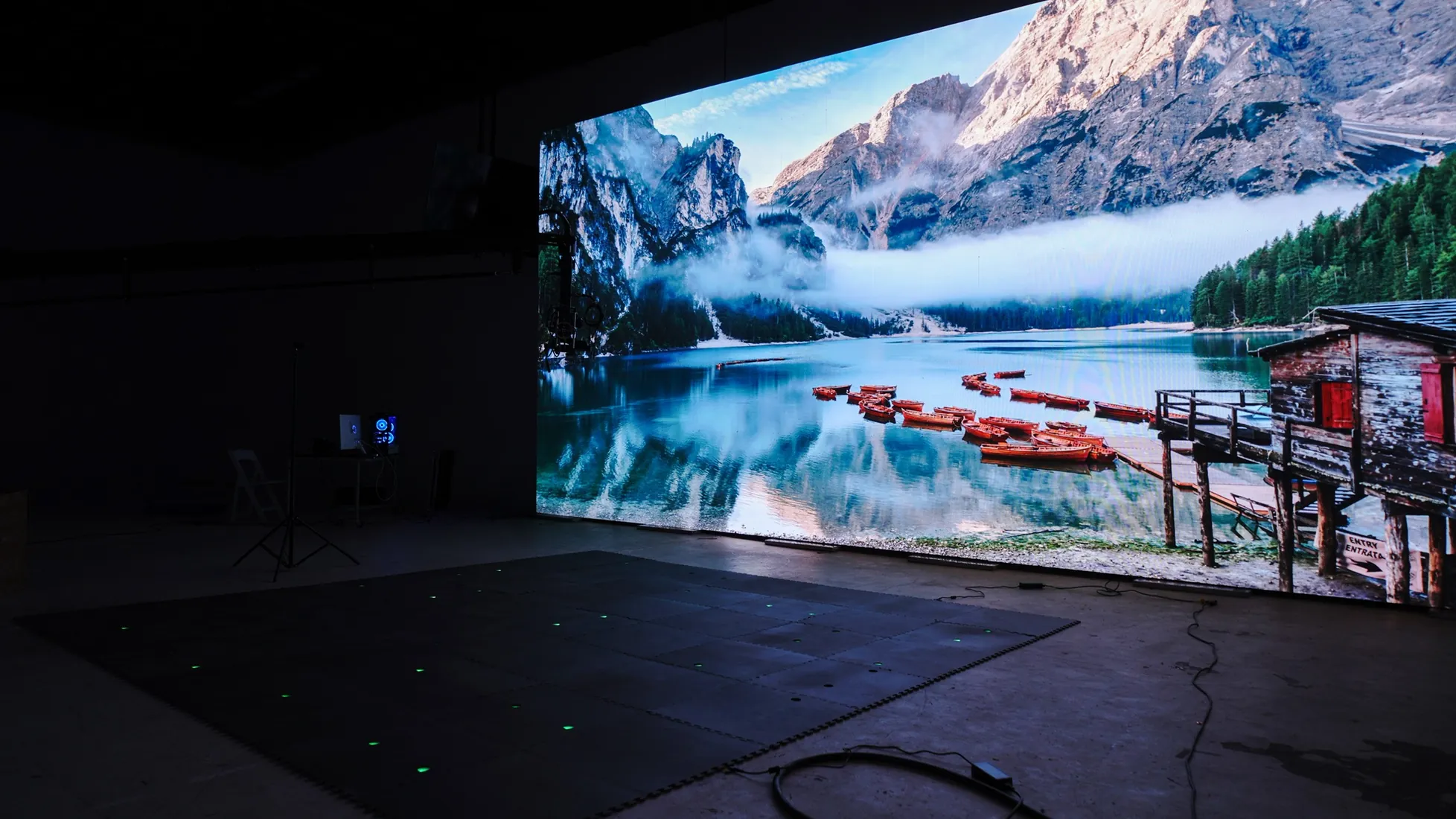 An LED wall showing a mountain lake on a dark stage.