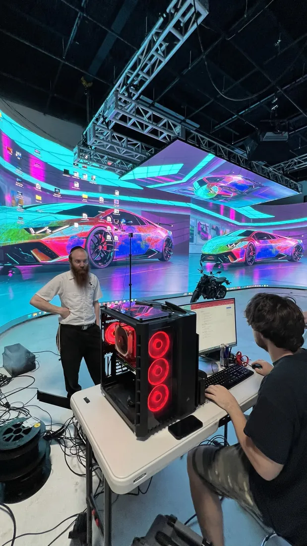 Crew at a workstation on a colorful LED set.